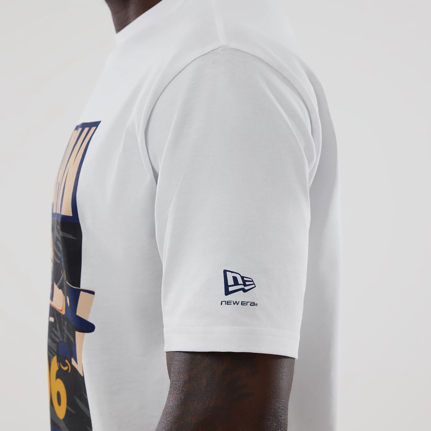 New Era Williams Japan 1996 White Oversized T-Shirt, side view on-model showcasing the large printed graphic on the front, short sleeves featuring a blue embroidered New Era logo near the hem, and a relaxed cut highlighting the design.