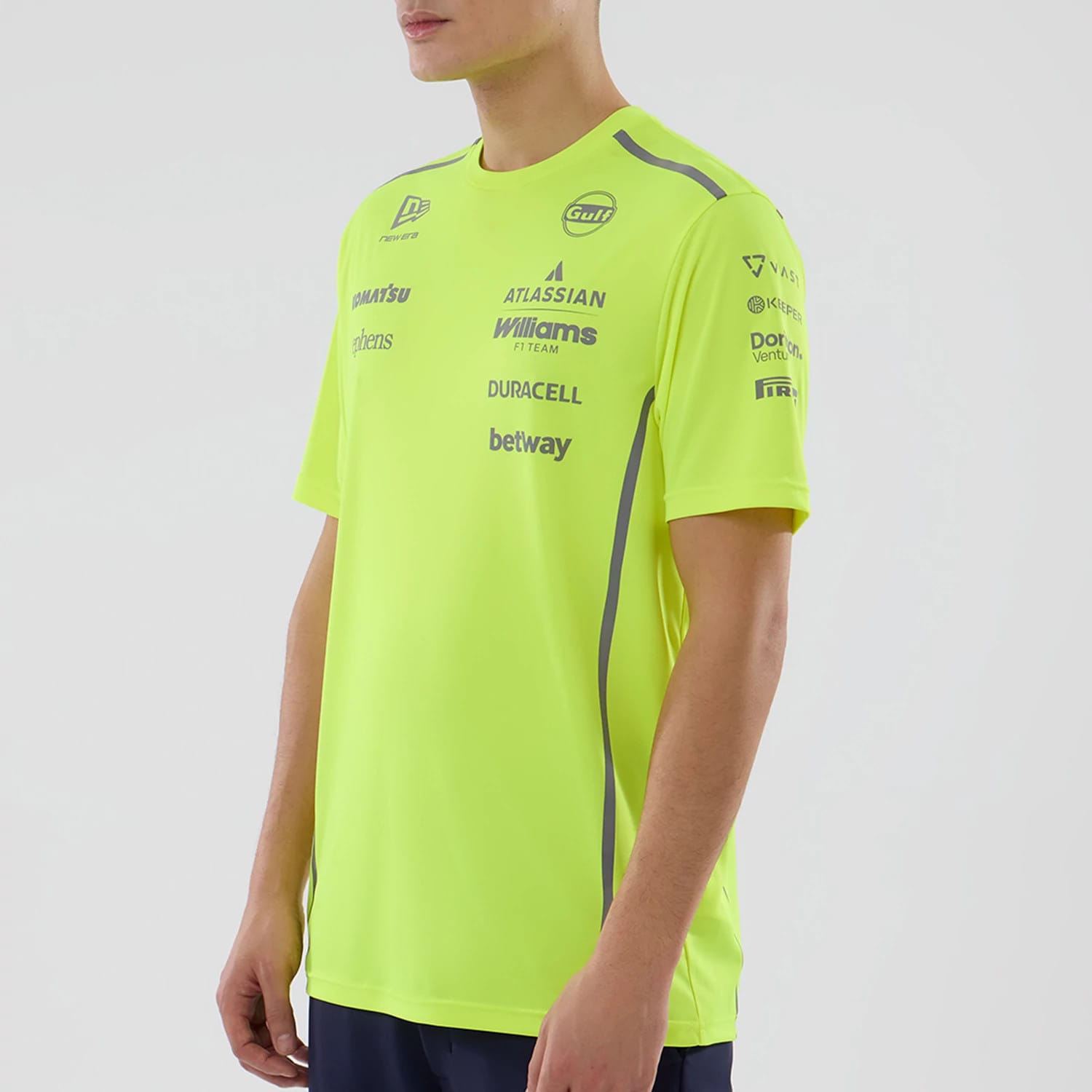 New Era Williams Set Up Yellow T-Shirt, three-quarter view showing the bright yellow shirt with multiple sponsor logos including Williams and Duracell printed on the chest and sleeves in dark blue, and a New Era logo on the shoulder.
