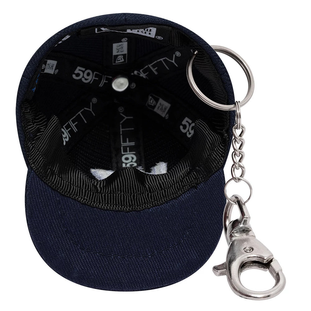 New Era Williams Navy Cap Key Chain, inside view showing a miniature cap with black sweatband and New Era 59FIFTY taping, attached to a silver key ring and clip, highlighting the detailed stitching and navy fabric.