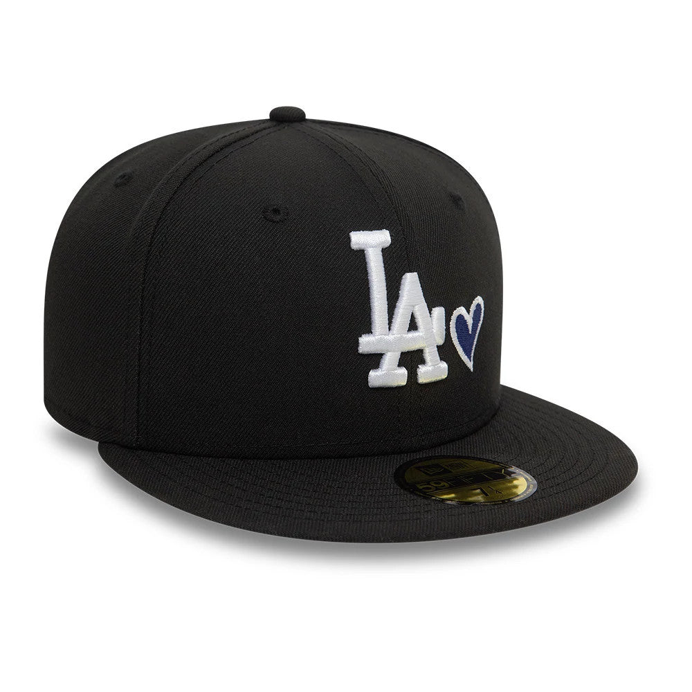 LA Dodgers MLB Heart Icon Black New Era 59FIFTY Fitted Cap, front view showing the raised white LA logo and blue heart icon on the structured black crown, with a flat black visor and gold 59FIFTY size sticker on display.