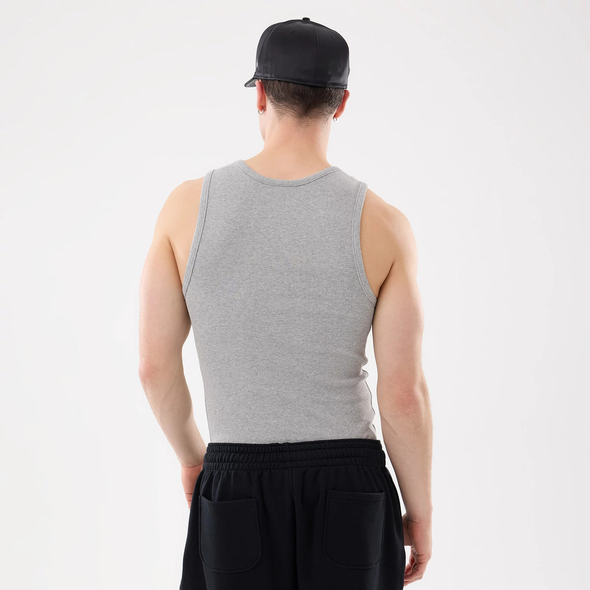 New Era LA Dodgers MLB Rib Grey Vest, rear view on a model showing the ribbed texture of the grey fabric, fitting snugly across the back, and contrasted by black sweatpants with back pockets.