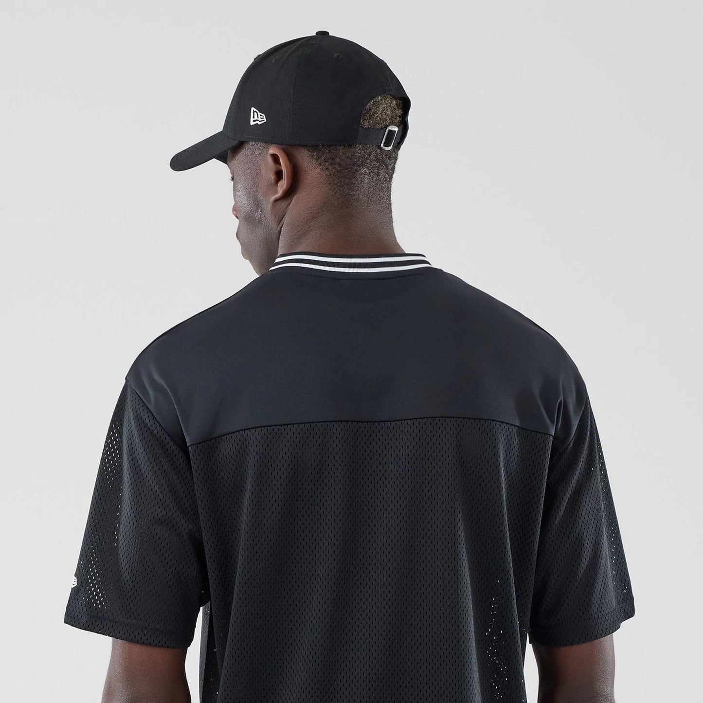 The model is wearing this New Era Mesh Oversized T-Shirt in black. 7