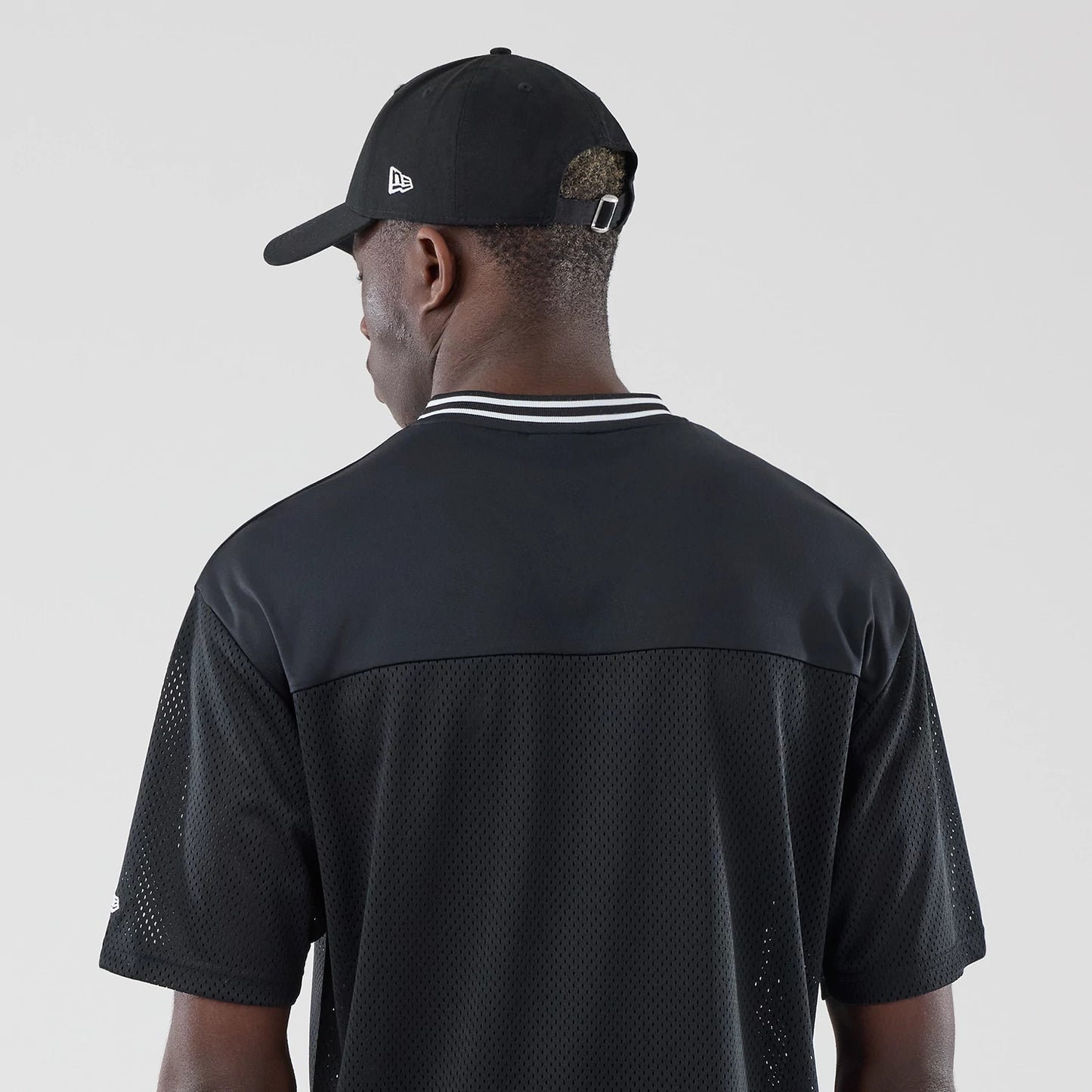 The model is wearing this New Era Mesh Oversized T-Shirt in black. 7