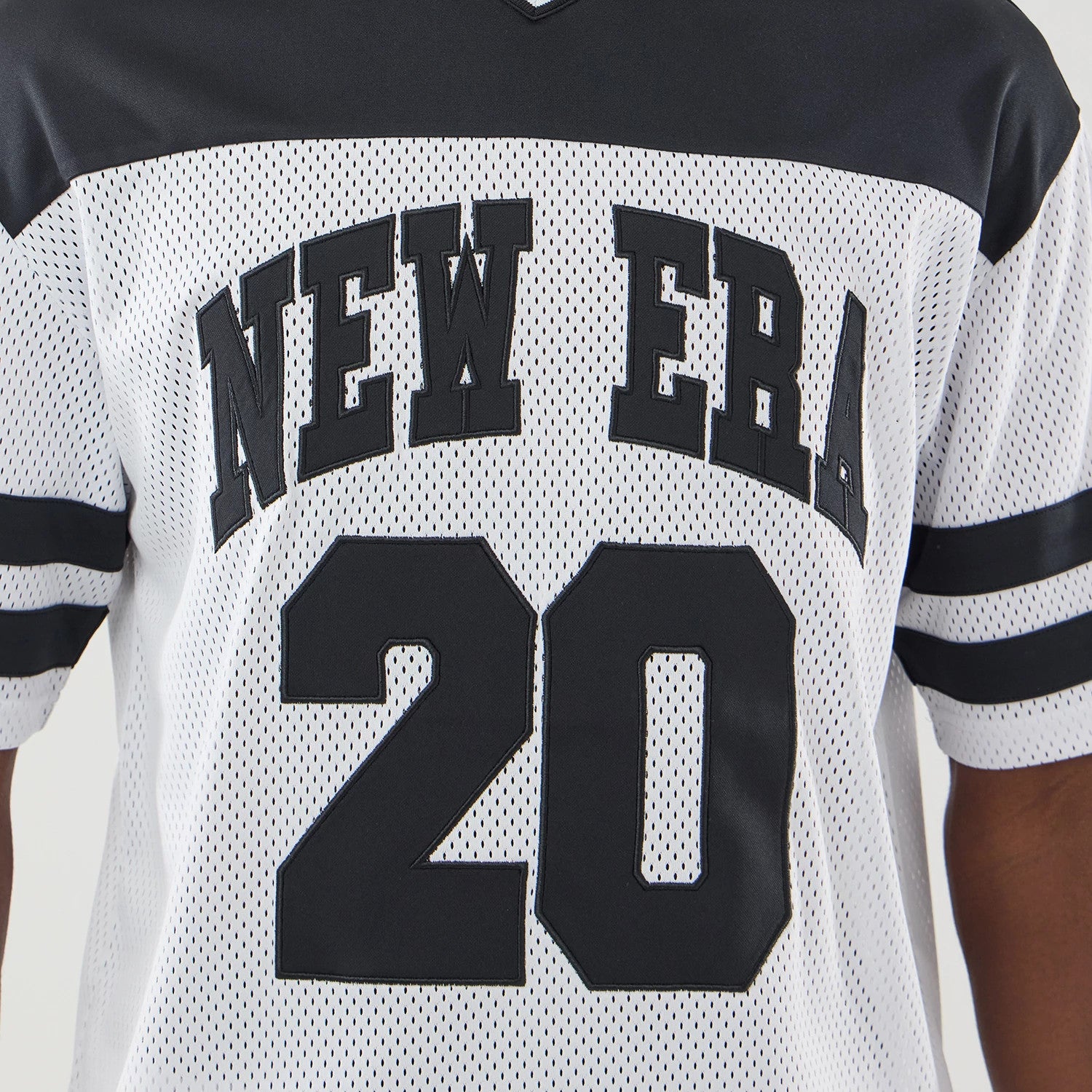 The model is wearing this New Era Mesh Oversized T-Shirt in white. 4