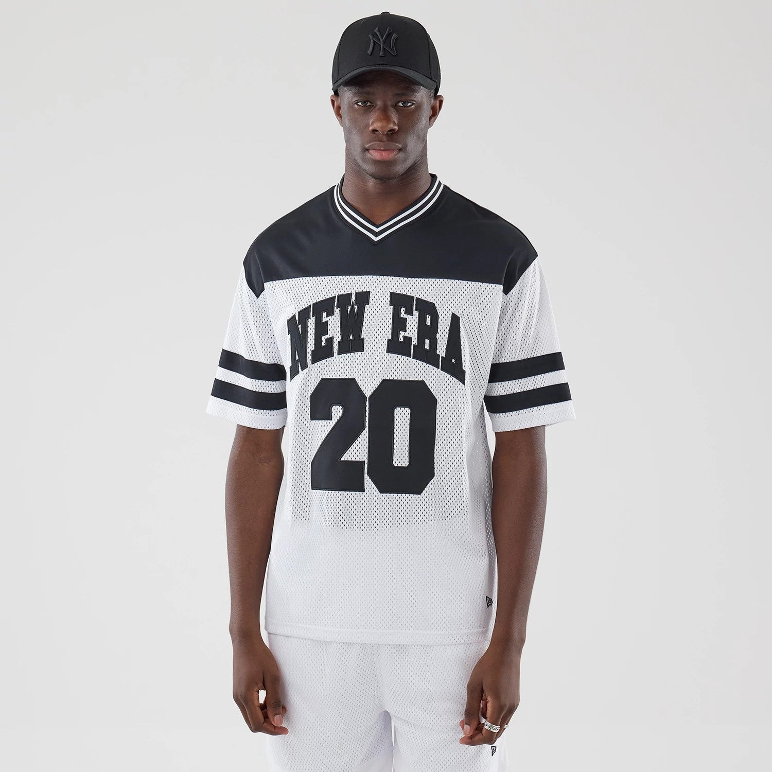 The model is wearing this New Era Mesh Oversized T-Shirt in white. 1