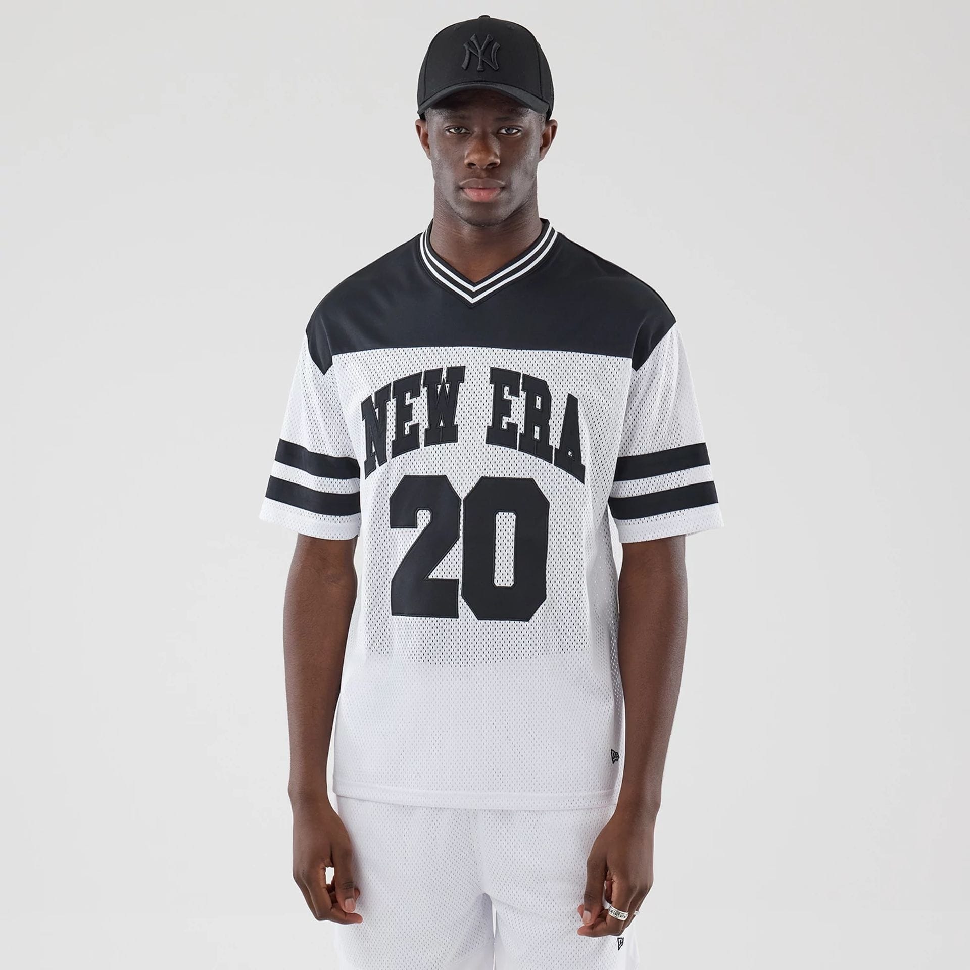 The model is wearing this New Era Mesh Oversized T-Shirt in white. 1