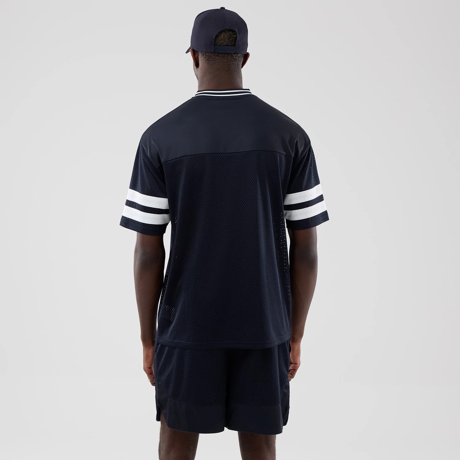The model is wearing this New Era Mesh Oversized T-Shirt in navy. 2