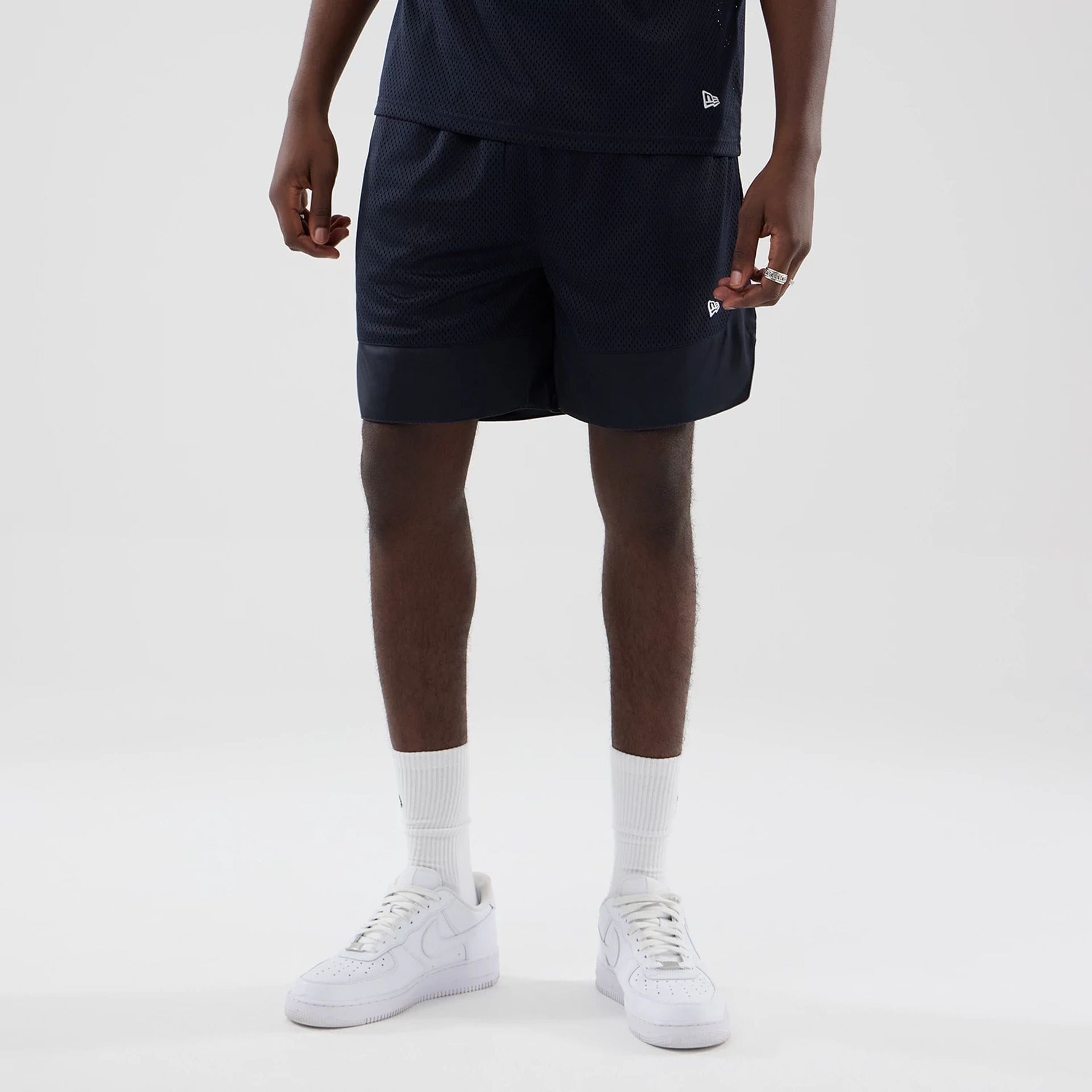 The model is wearing this New Era Mesh Oversized Shorts in navy. 1
