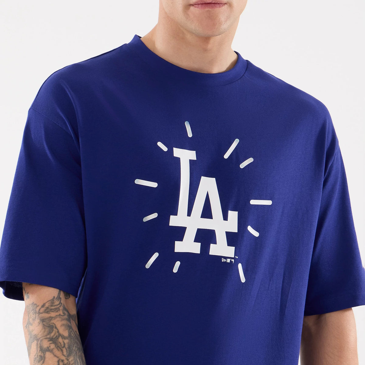 New Era LA Dodgers MLB 59FIFTY Day Graphic Dark Blue T-Shirt, front view on a model showing a white LA Dodgers logo with radiating lines on the chest, short sleeves with a relaxed fit and a New Era logo tag near the hem.