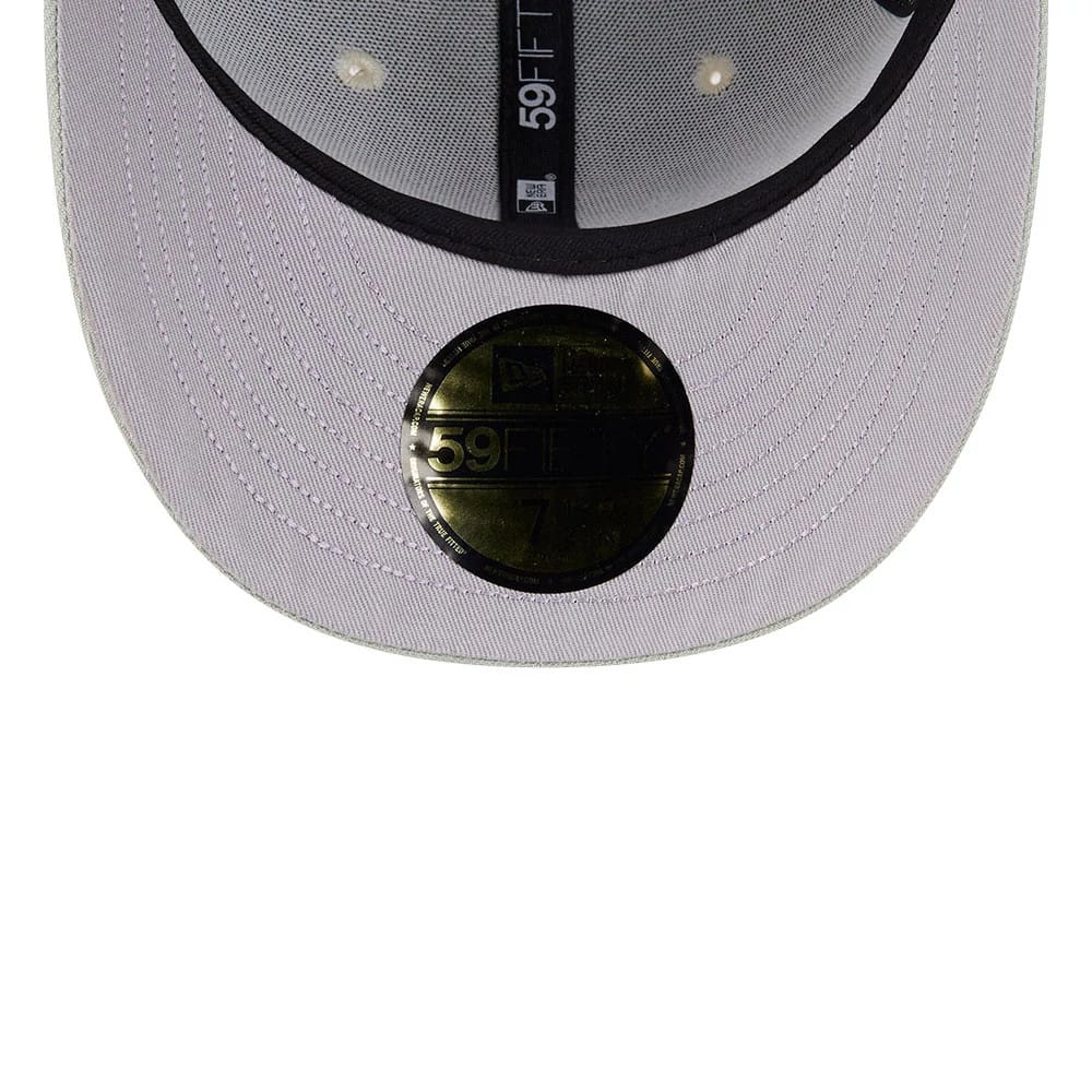 LA Dodgers MLB Pastel Green New Era 59FIFTY Fitted Cap, inside view showing the black printed taping with 59FIFTY branding, a gold 59FIFTY size sticker on the lavender undervisor, and the black sweatband lining the interior.