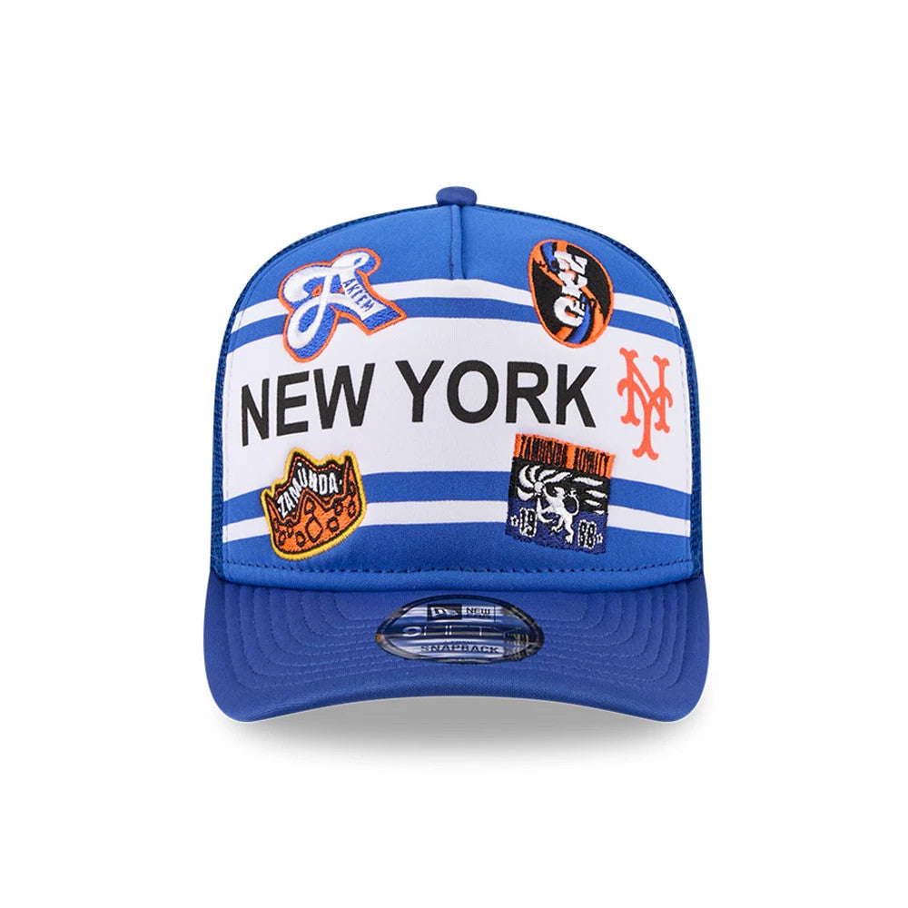 Mets MLB X Coming To America Blue New Era 9FIFTY A-Frame Snapback Adjustable Cap, front view showing a embroidered New York text across white and blue striped panels, with multiple colourful embroidered patches.