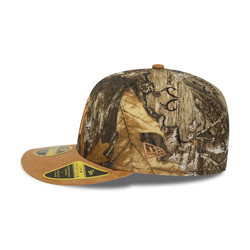 New York Yankees MLB Realtree Assorted Print Low Profile New Era 59FIFTY Fitted Cap, side view with the unique woodland camo pattern, brown flat visor featuring a gold 59FIFTY size sticker, and New Era flag logo embroidered on the left side.