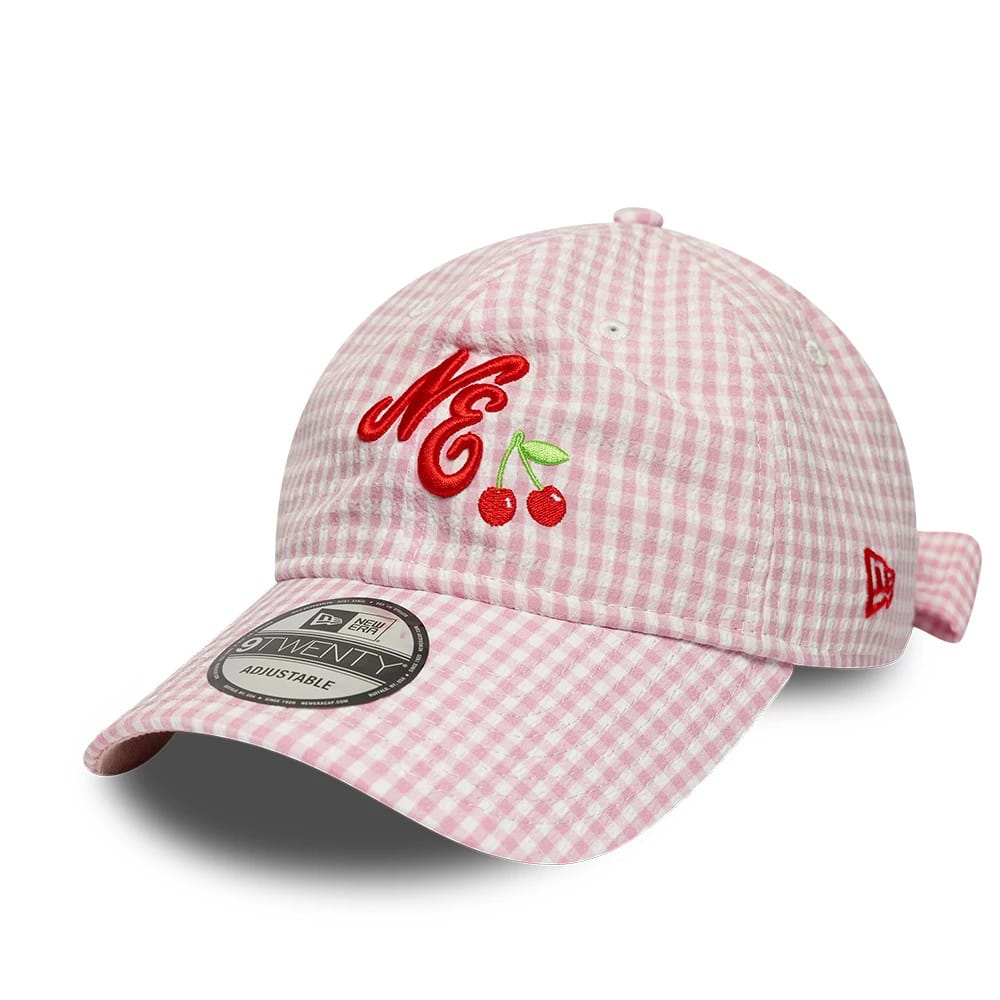 New Era Gingham Bowback Pastel Pink 9TWENTY Adjustable Cap, front view showing red embroidered NE with cherry graphic on the pink gingham checked front panel, curved visor with a 9TWENTY size sticker, and red New Era flag on the left side.