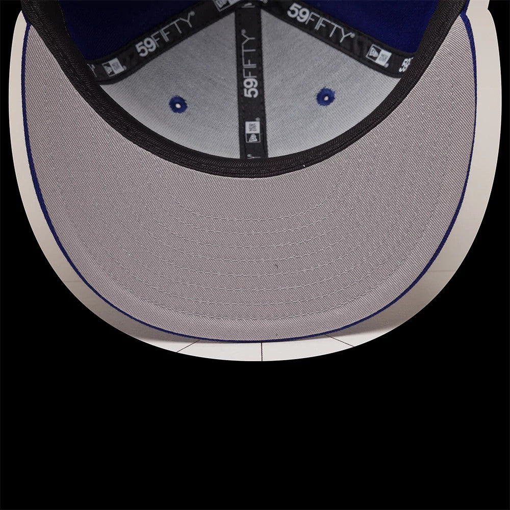 LA Dodgers MLB Emblem Dark Blue New Era 59FIFTY Fitted Cap, inside view showing a light grey undervisor, black 59FIFTY taping along the seams, and blue eyelets matching the interior fabric, illustrating its craftsmanship and finish.