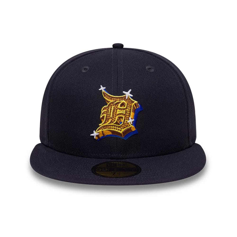 Detroit Tigers MLB Emblem Navy New Era 59FIFTY Fitted Cap, front view showing an intricately embroidered gold and blue Tigers emblem on the structured navy crown, with a flat visor and black 59FIFTY size sticker on the underside of the visor.