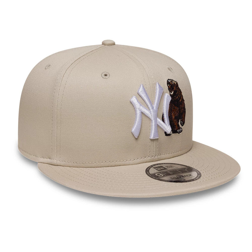 Yankees MLB Outdoor Icon Light Beige New Era 9FIFTY Snapback Adjustable Cap, front view showing a white embroidered NY logo and a detailed bear graphic on the front panel, with a beige flat visor and a 9FIFTY size sticker.