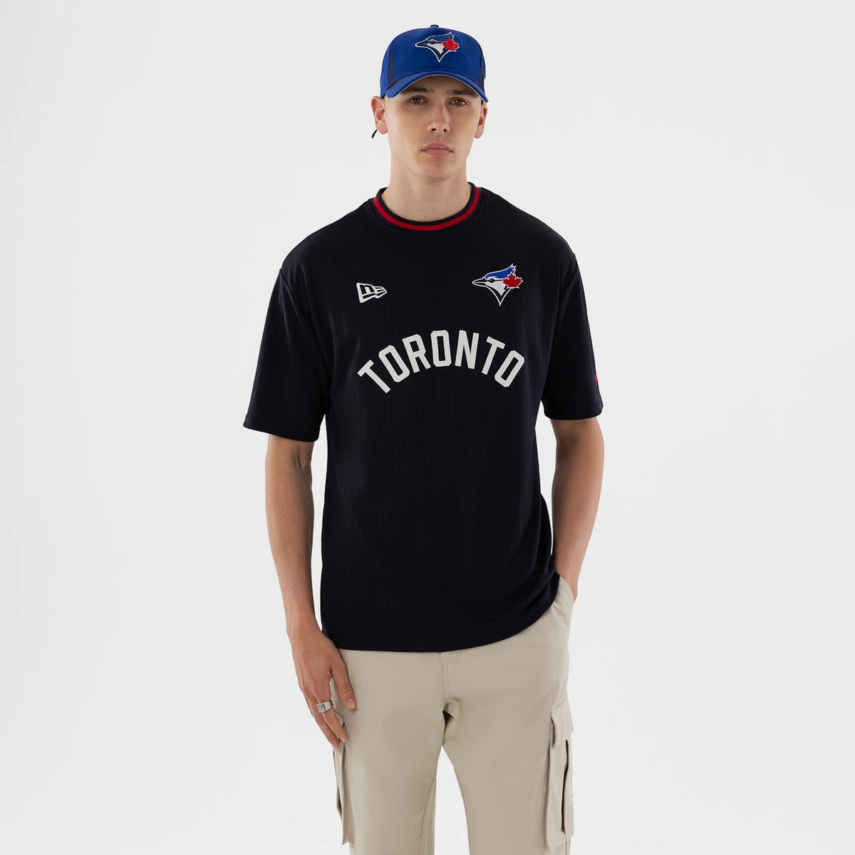 New Era Toronto Blue Jays MLB Navy Oversized T-Shirt, front view on a model with matching blue cap, showing white Toronto lettering across the chest, a small embroidered team logo on the right and a New Era logo on the left.