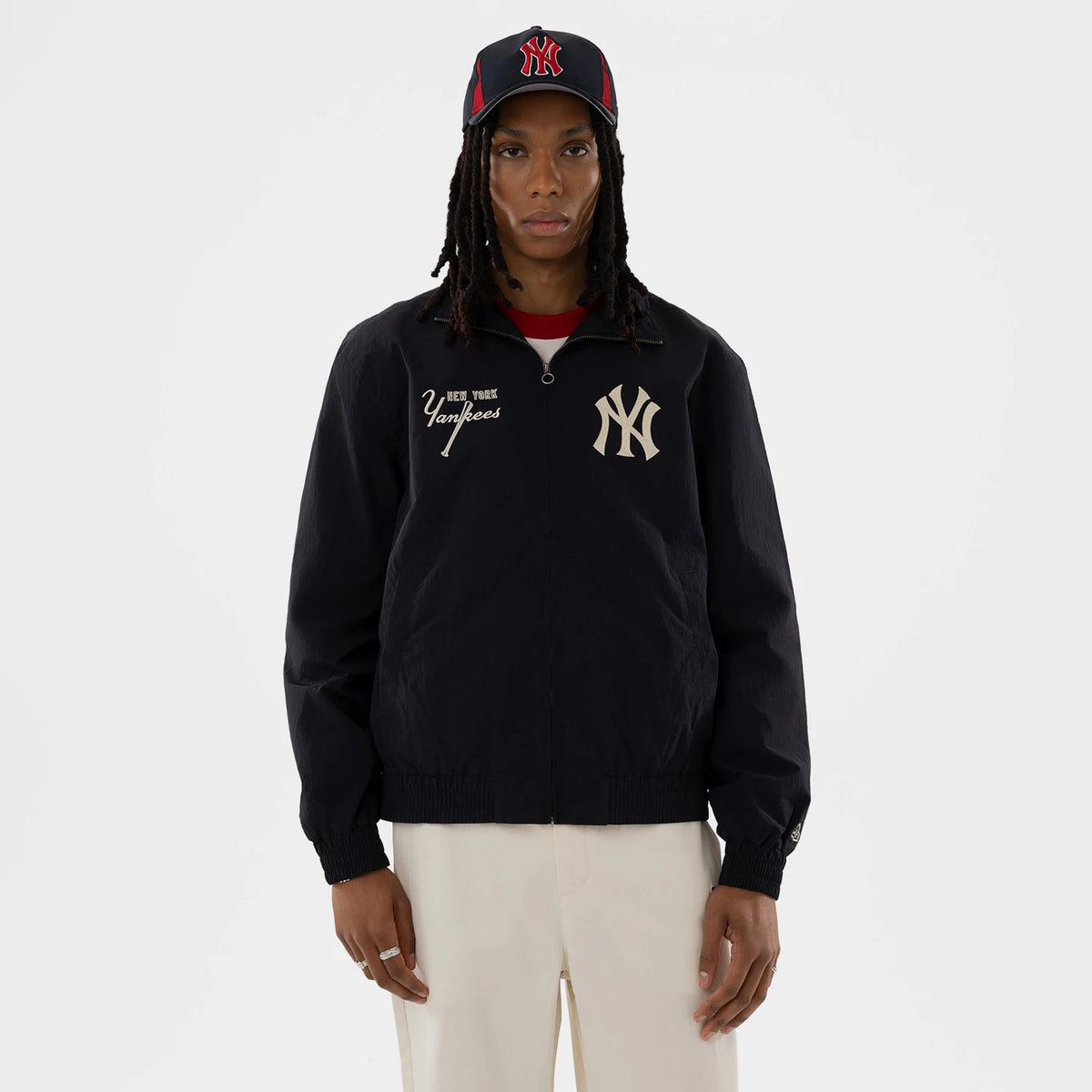 New Era New York Yankees MLB Navy Sports Jacket, front view on-model showing the large embroidered NY logo on the left chest, 'New York Yankees' script embroidered in white on the right, and a full zipped front with ribbed cuffs.