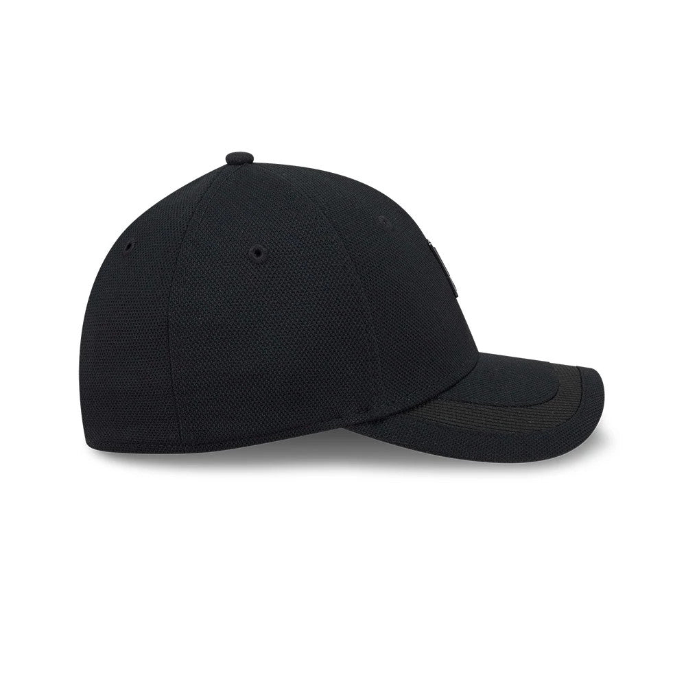 New Era Golf Rubber Patch Black New Era 39THIRTY M-Crown Stretch Fit Cap, side view showing the black New Era flag logo on the left side, a curved black visor, and a structured crown with embroidered eyelets for ventilation.