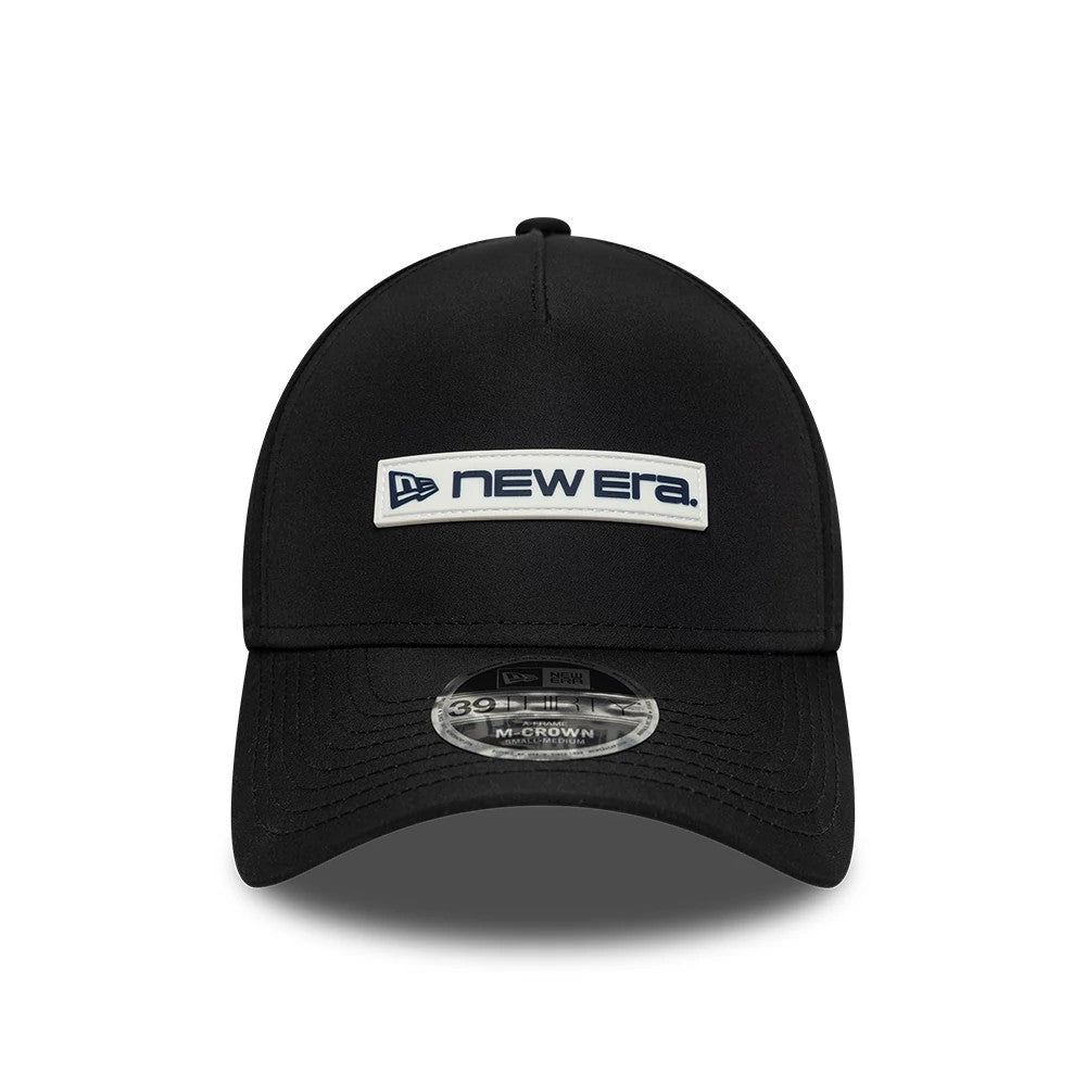 New Era Rubber Patch Black New Era 39THIRTY M-Crown A-Frame Stretch Fit Cap, front view showing a white and navy embroidered New Era logo patch on the centre panel, a curved black visor, and a 39THIRTY size sticker on the visor.