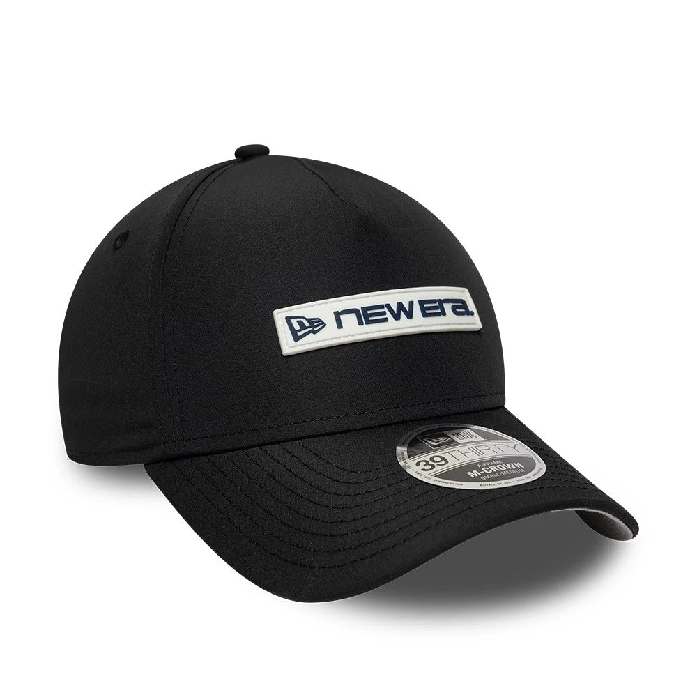 New Era Rubber Patch Black New Era 39THIRTY M-Crown A-Frame Stretch Fit Cap, front view showing a black crown with a white and navy New Era patch logo on the front panel, a curved black visor, and a 39THIRTY size sticker.