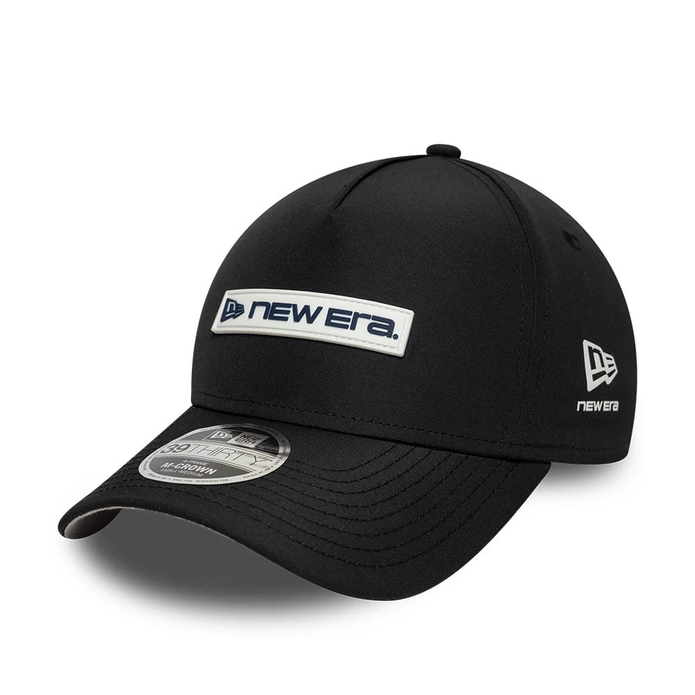 New Era Rubber Patch Black New Era 39THIRTY M-Crown A-Frame Stretch Fit Cap, three-quarter view showing a black curved visor with a 39THIRTY size sticker, a New Era logo patch on the front panel, and an embroidered New Era flag on the left side.