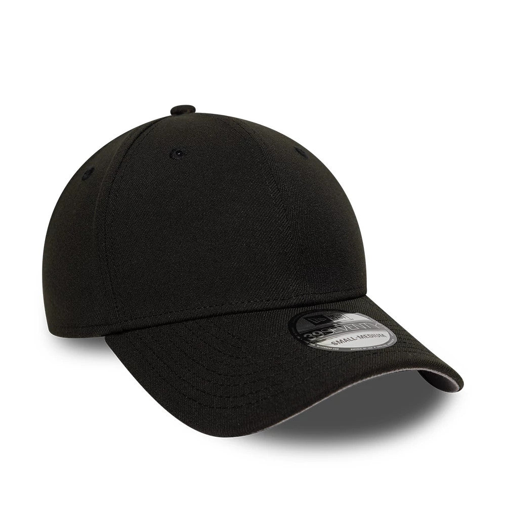 New Era Mono Black 39SEVENTY Stretch Fit Cap, three-quarter view showing a curved black visor with the 39SEVENTY size sticker, six embroidered eyelets around the structured crown, and a black top button.