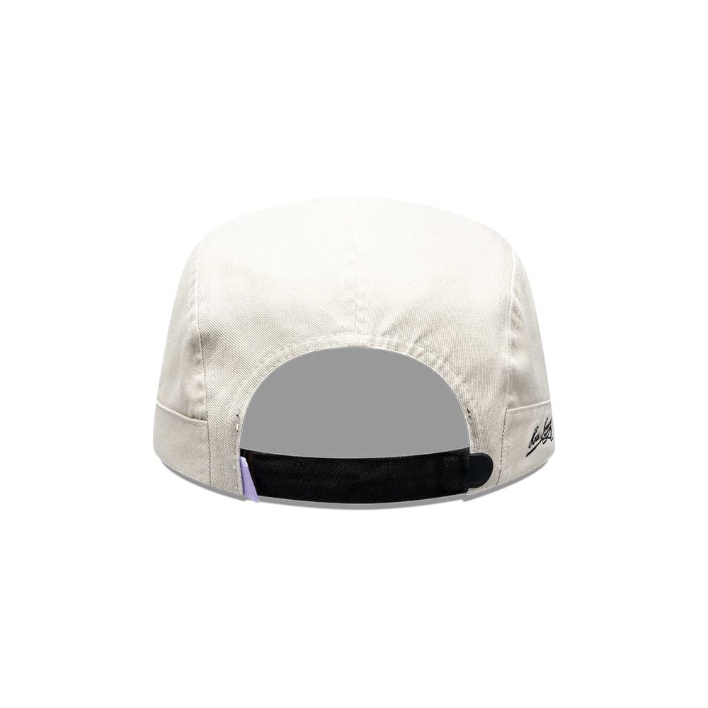New Era X Hermanos Koumori Running Light Beige Camper Cap, rear view showing a black adjustable strap with a buckle at the back, a small purple tab detail, and delicate embroidered logo on the right side of the light beige crown.