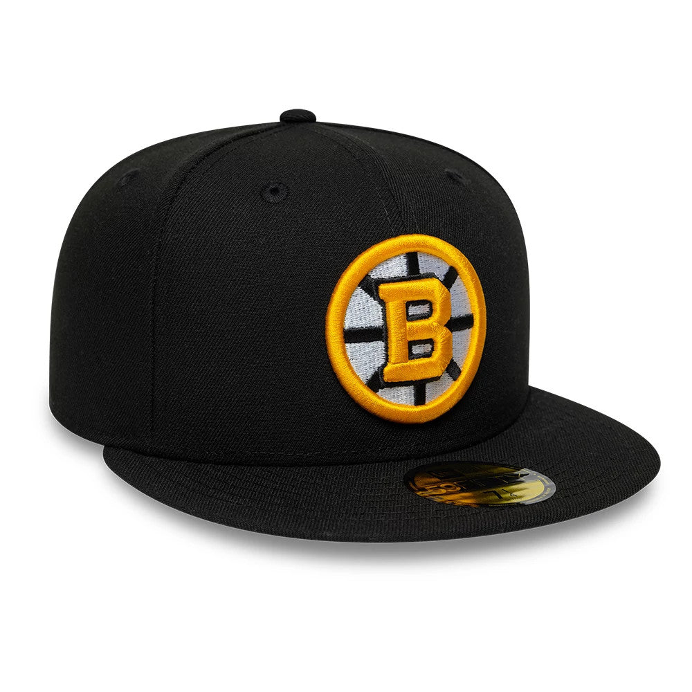Boston Bruins NHL Basic Black New Era 59FIFTY Fitted Cap, three-quarter view showing the raised golden B logo on the front panel, the black flat visor with a gold 59FIFTY size sticker, and the structured black crown with embroidered eyelets.
