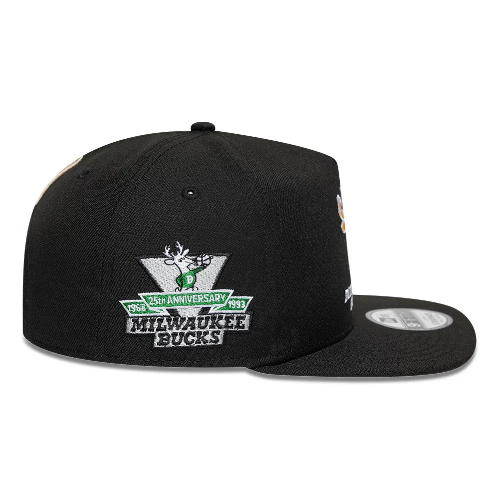 Bucks NBA Hardwood Classic Black New Era 9FIFTY A-Frame Snapback Adjustable Cap, side view showing the Milwaukee Bucks 25th Anniversary logo embroidered on the side panel, with a flat black visor and a 9FIFTY size sticker on top.