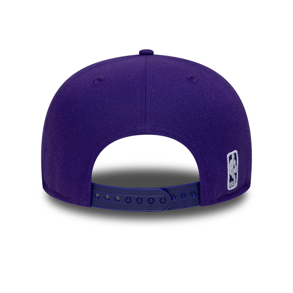 LA Lakers NBA Purple New Era 9FIFTY Snapback Adjustable Cap, rear view showing the silver embroidered NBA logo at the centre of the back panels, with a purple adjustable snap closure and eyelets on the structured purple crown.