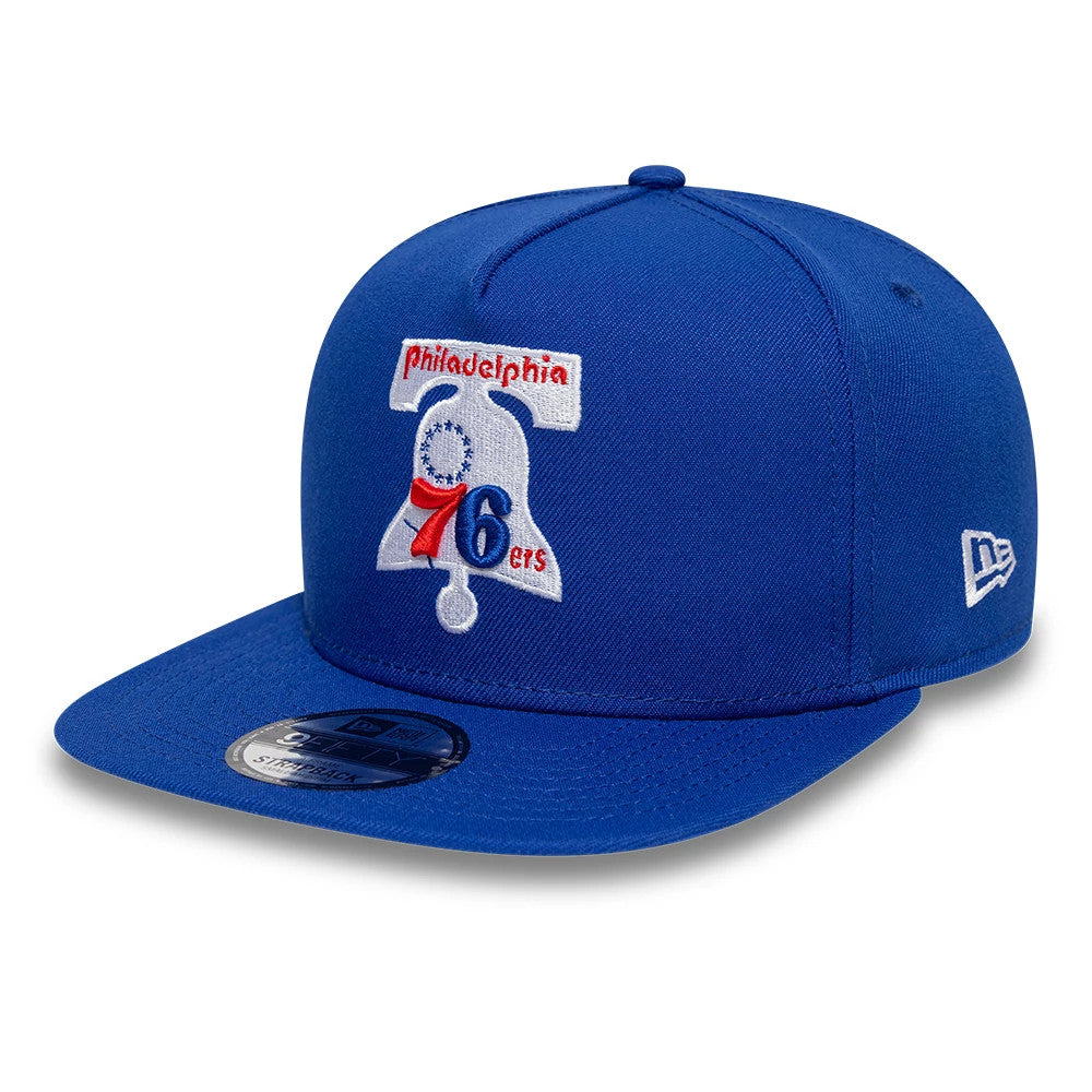 Philadelphia 76ers NBA Hardwood Classic Blue New Era 9FIFTY A-Frame Snapback Adjustable Cap, front view showing the embroidered bell logo with '76ers' in red and white on the blue structured crown, and the New Era flag logo on the left side.
