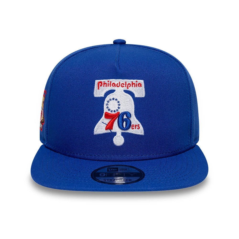 Philadelphia 76ers NBA Hardwood Classic Blue New Era 9FIFTY A-Frame Snapback Adjustable Cap, front view showing the raised embroidered Liberty Bell logo with red Philadelphia script and blue visor, featuring a 9FIFTY size sticker on the visor.