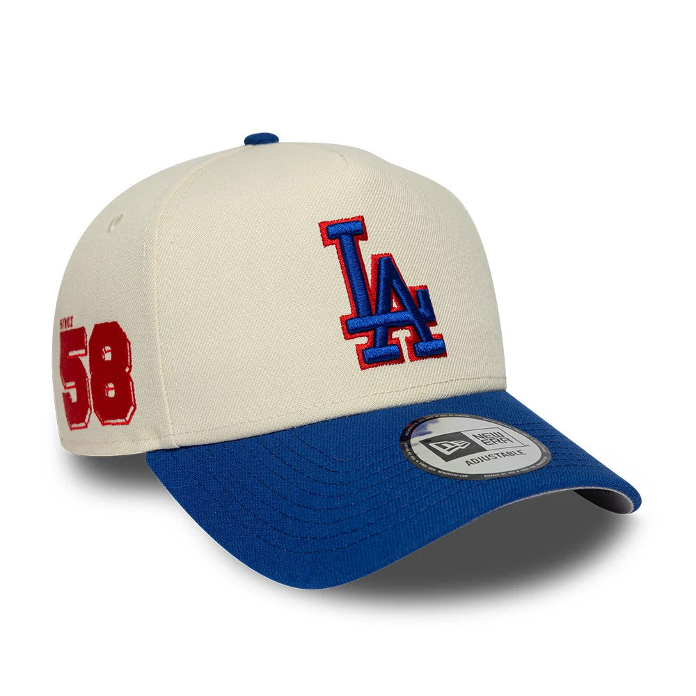 LA Dodgers MLB Side Hit Cream New Era 9FORTY E-Frame Adjustable Cap, three-quarter view showing the blue and red embroidered LA logo on the front panel, contrasting blue curved visor with a 9FORTY size sticker, and red '58' embroidery on the side.