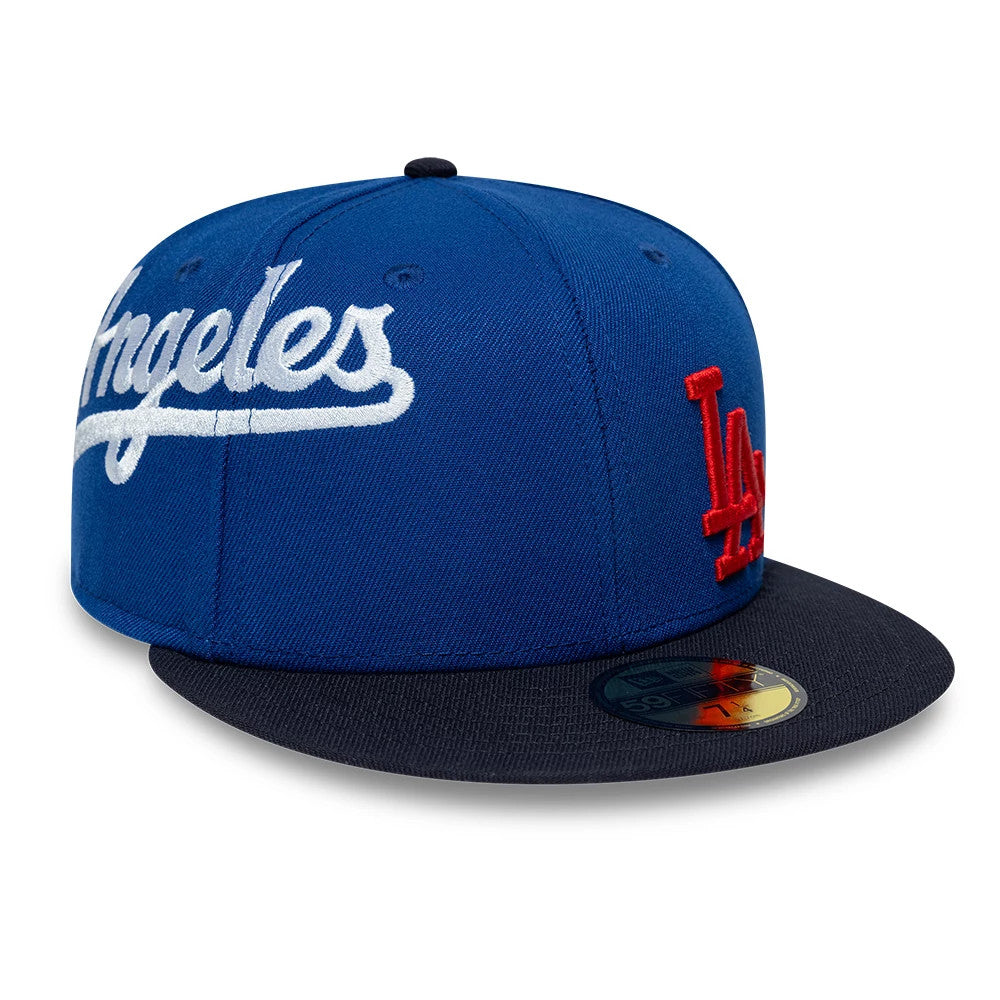 LA Dodgers MLB Multi Logo Satin Lined Blue New Era 59FIFTY Fitted Cap, three-quarter view showing the white Los Angeles script on the front panel, red LA logo on the right side, and a contrasting black flat visor with a gold 59FIFTY size sticker.