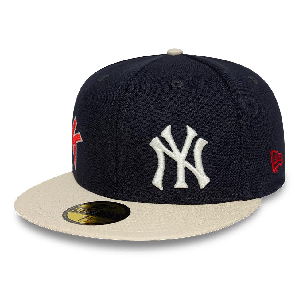 New York Yankees MLB Multi Logo Satin Lined Navy New Era 59FIFTY Fitted Cap, three-quarter view showing the large white raised embroidered Yankees logo on the front panel, a contrasting beige visor, and red New Era flag logo on the left side.