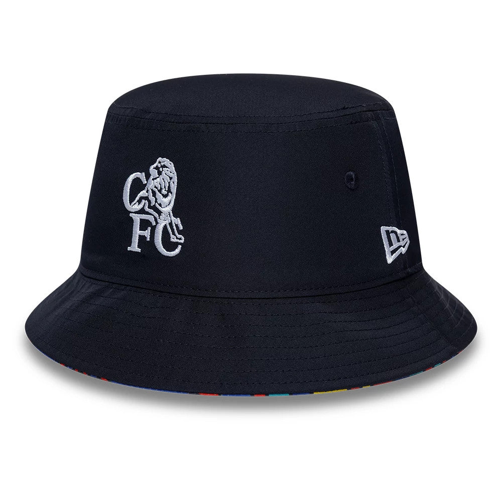 New Era Chelsea FC Retro Goal Keeper Navy Reversible Bucket Hat, side view showing the white embroidered CFC lion crest on the front, the New Era flag logo on the left side, and a multicoloured patterned visor edge.