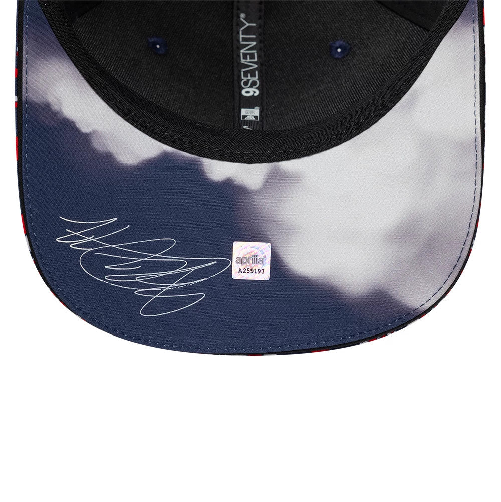 Aprilia Replica Silverstone Race Special Blue New Era 9SEVENTY Stretch Snap Adjustable Cap, inside view showing a printed visor with a signature, holographic sticker, black 9SEVENTY taping along the seam, and a dark sweatband edge.