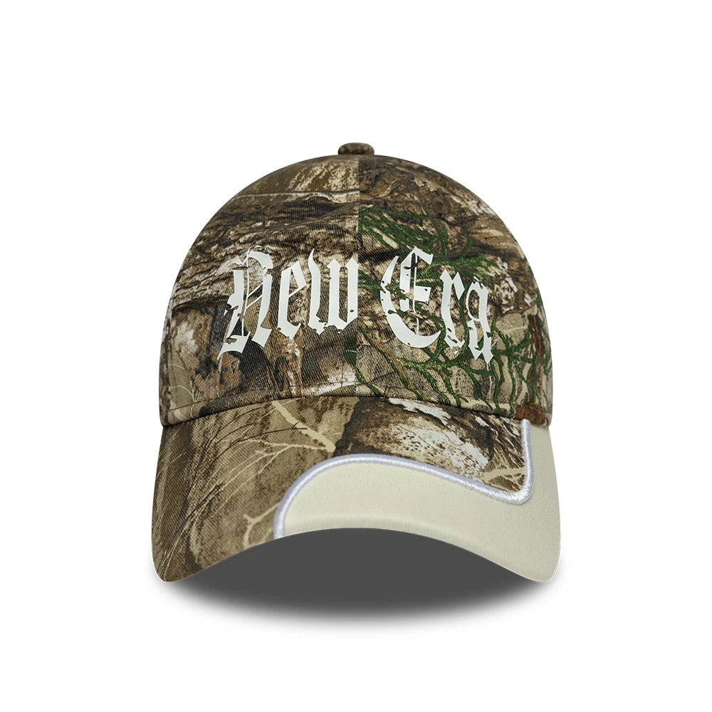New Era Real Tree Print 9TWENTY Adjustable Cap, front view showing white Gothic-style embroidered 'New Era' script on the camo crown, with a beige curved visor featuring a white edge trim.