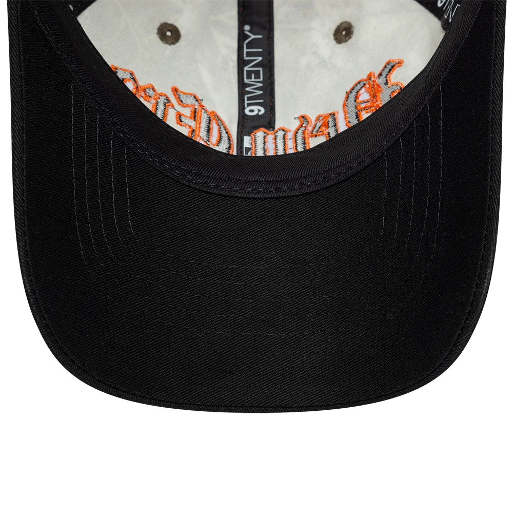 New Era Real Tree Assorted Print 9TWENTY Adjustable Cap, inside view showing orange embroidered lettering on the inner crown, black fabric taping featuring the 9TWENTY logo, and a black curved visor attached to the structured front panel.