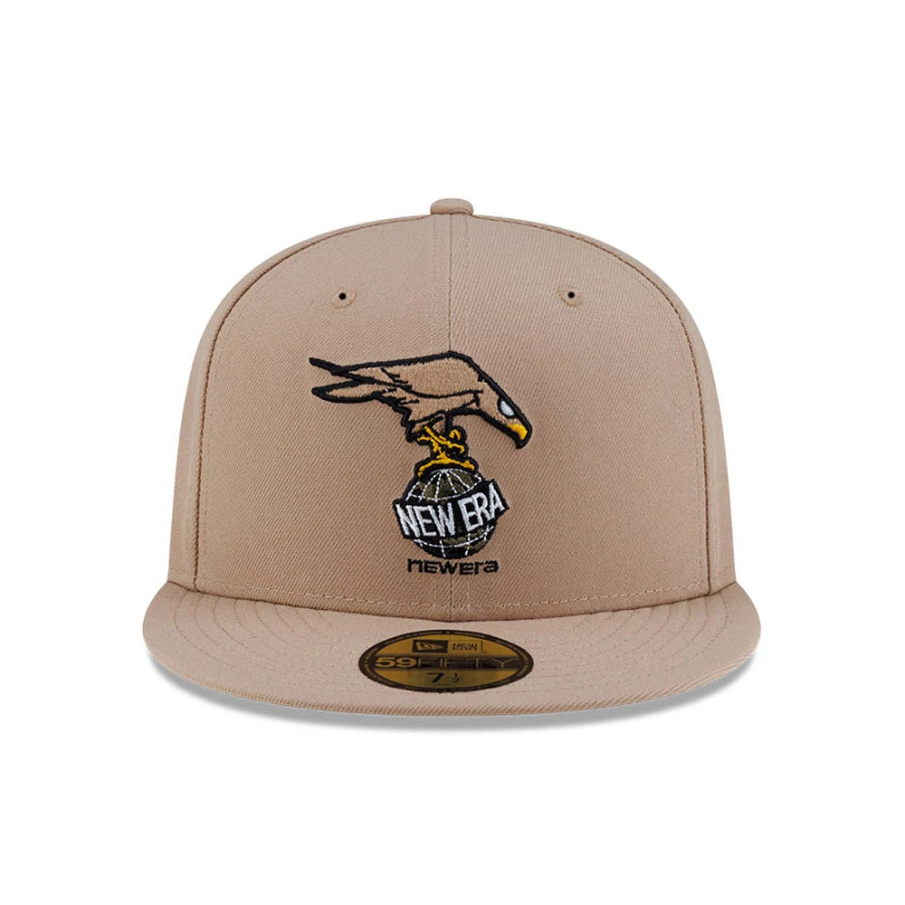 Roji Soccer Beige New Era 59FIFTY Fitted Cap, front view showing a detailed embroidered graphic of a bird with a New Era globe logo on the beige front panel, complemented by a flat beige visor and a gold 59FIFTY size sticker.
