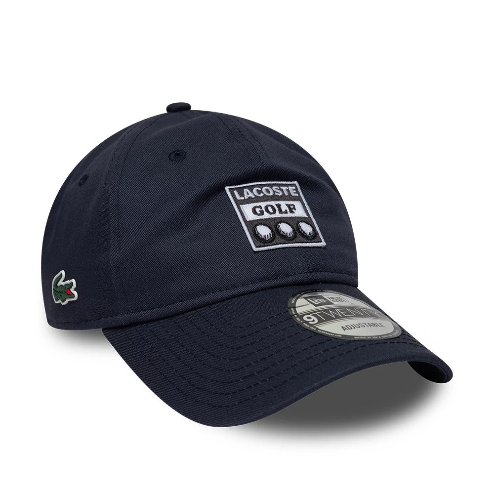Lacoste X New Era Dark Blue 9TWENTY Adjustable Cap, front view showing the embroidered Lacoste Golf patch on the structured crown, the green Lacoste logo on the side, and the 9TWENTY size sticker on the curved visor.