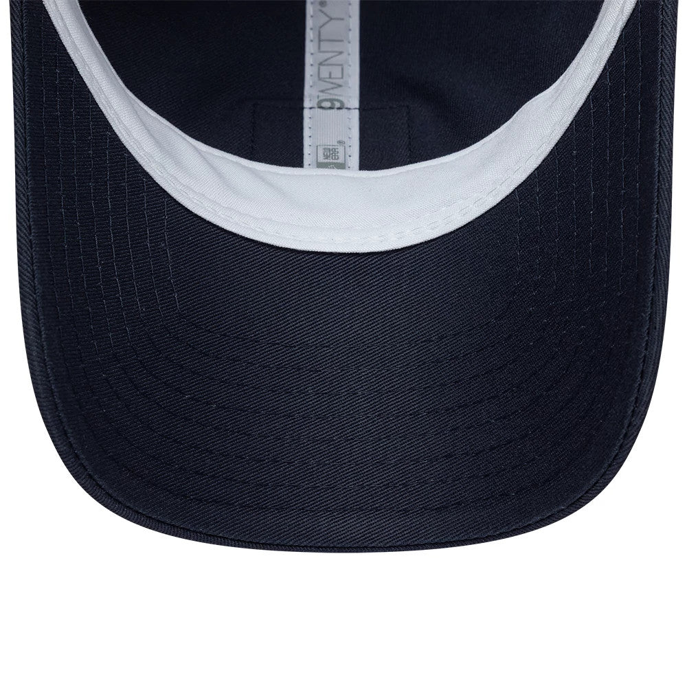 Lacoste X New Era Dark Blue 9TWENTY Adjustable Cap, inside view showing the white inner sweatband lining the crown, a 9TWENTY branding label along the taping, and a close-up of the dark blue underside of the curved visor.