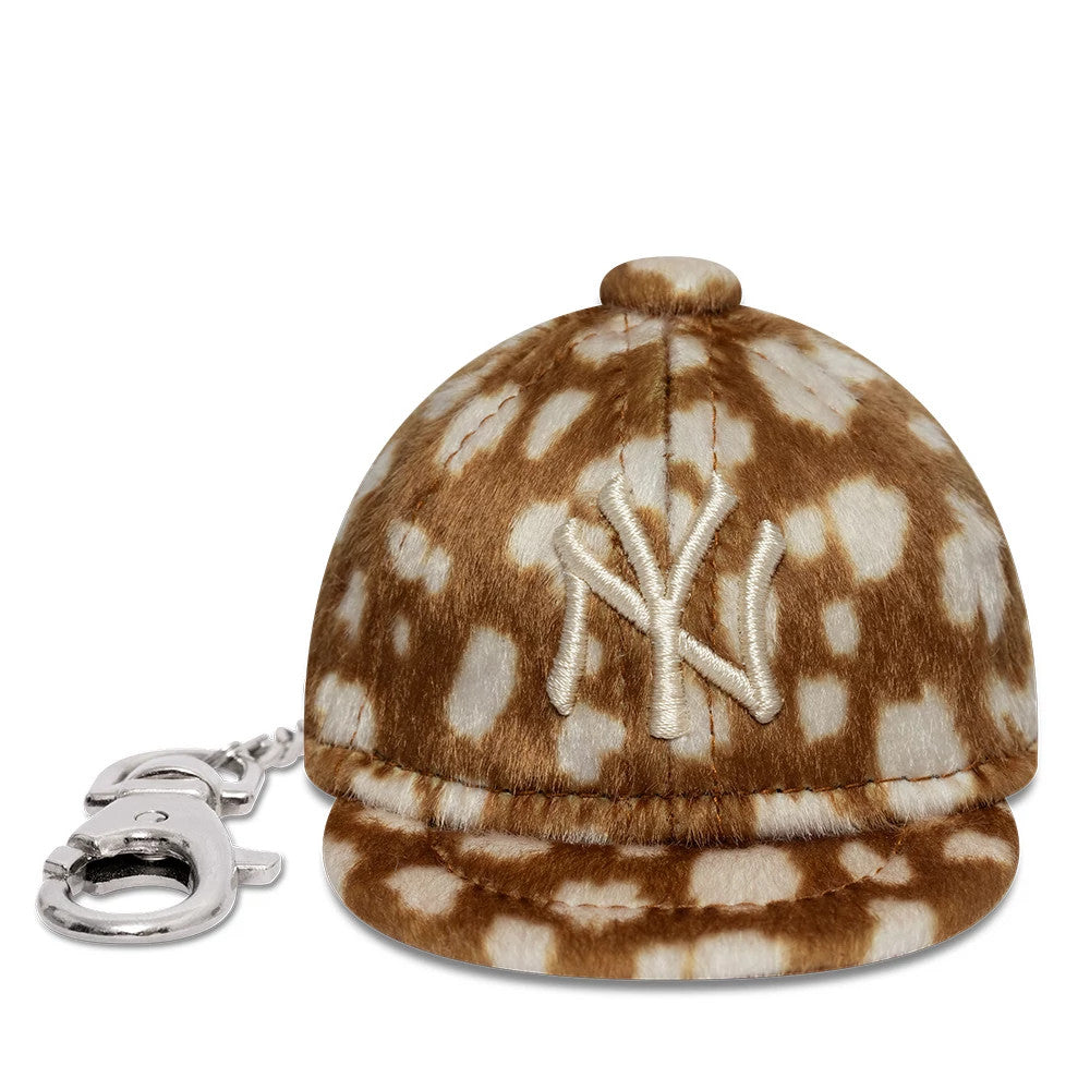 New Era New York Yankees MLB Animal Mini Cap Light Brown Key Chain, front view showing the white embroidered NY logo on a light brown and cream spotted plush cap with a small visor and a silver keychain attachment on the side.