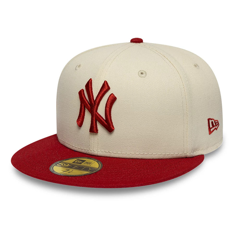 New York Yankees MLB League Essential Cream & Red New Era 59FIFTY Fitted Cap, three-quarter view showing a raised red embroidered NY logo on the front panel, a red visor with a gold 59FIFTY size sticker, and the New Era flag logo on the left side.