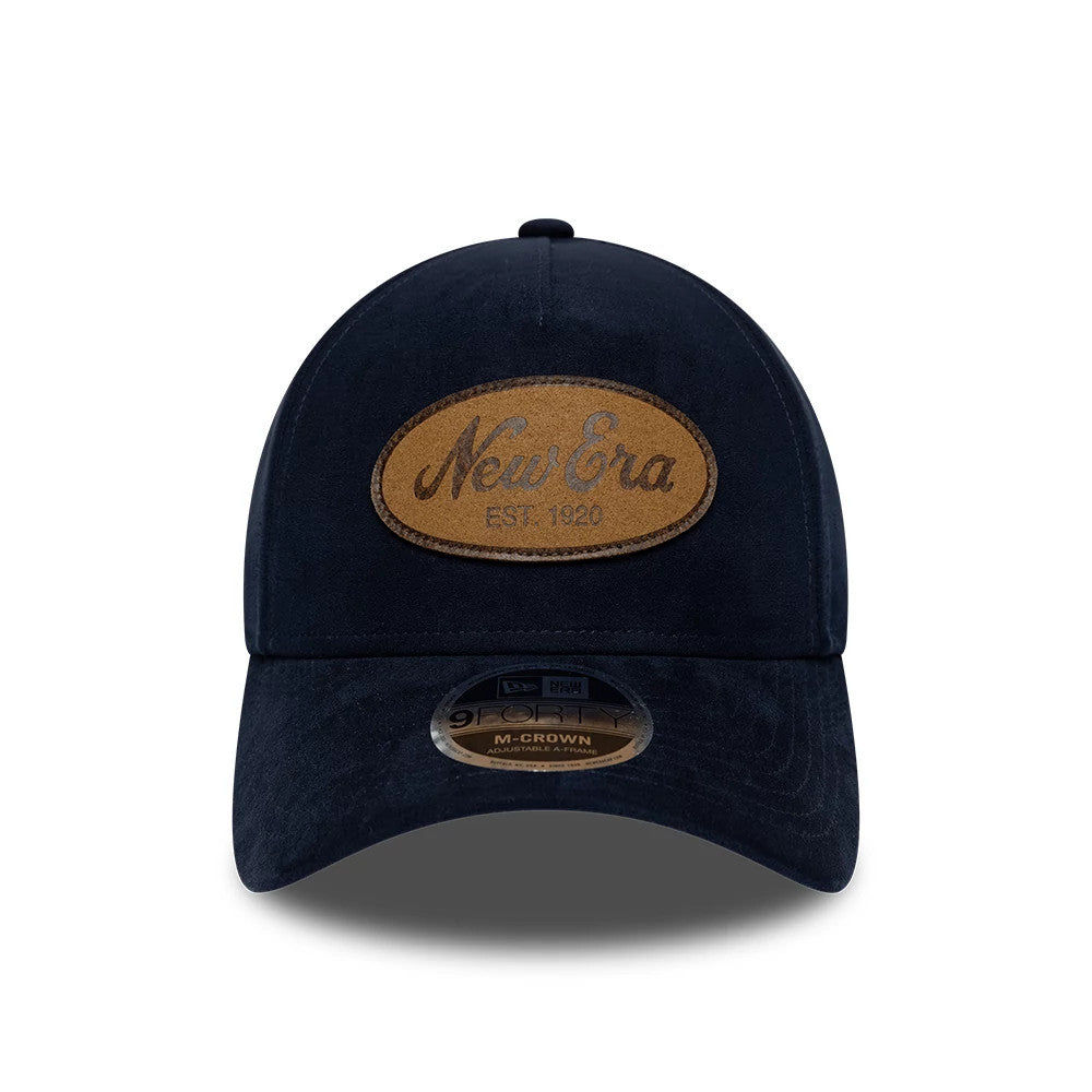 New Era Faux Suede Navy 9FORTY M-Crown A-Frame Adjustable Cap, front view showing a large oval faux suede patch with embossed New Era script and Est. 1920 on the navy structured crown, complete with a 9FORTY size sticker on the curved visor.
