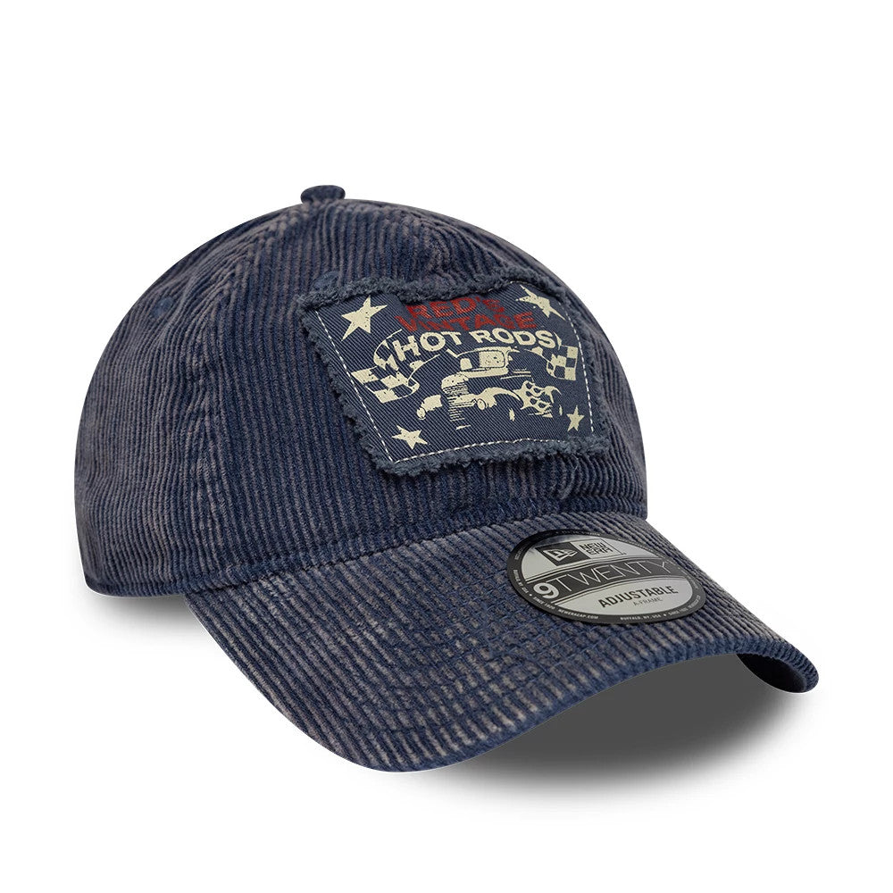 New Era Patch Acid Cord Dark Blue New Era 9TWENTY Adjustable Cap, three-quarter view showing a unique vintage-inspired patch on the front panel with hot rod graphics, a black 9TWENTY size sticker on the curved visor, and corduroy fabric texture.