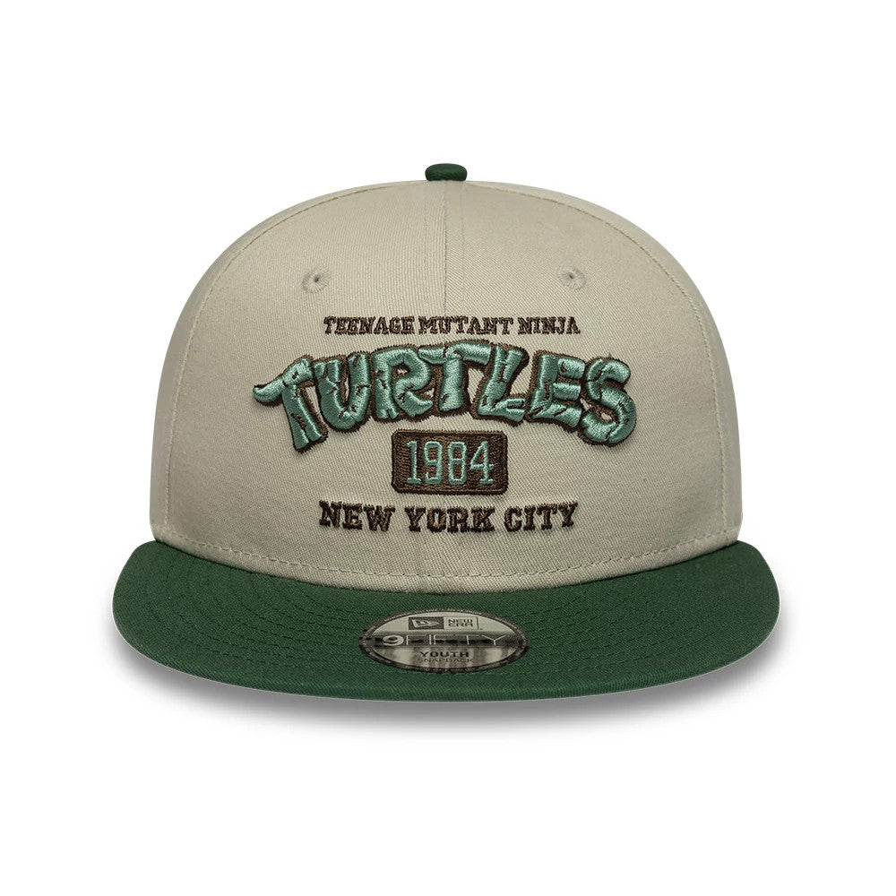 Youth Teenage Mutant Ninja Turtles Beige New Era 9FIFTY Snapback Adjustable Cap, front view showing raised embroidery of the Turtles logo in green, brown text reading Teenage Mutant Ninja and New York City.