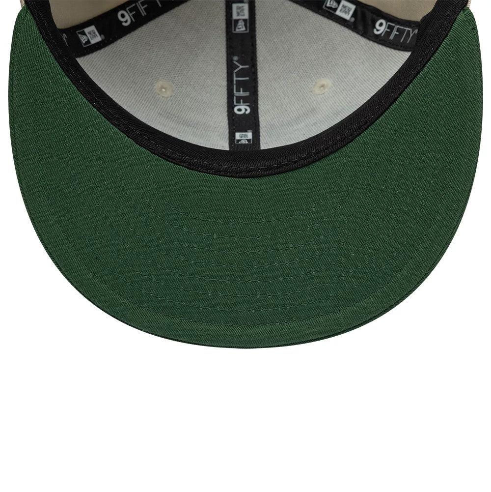 Youth Teenage Mutant Ninja Turtles Beige New Era 9FIFTY Snapback Adjustable Cap, inside view showing a green undervisor with stitching, black taping with repeated 9FIFTY branding, and a grey sweatband lining the cap.