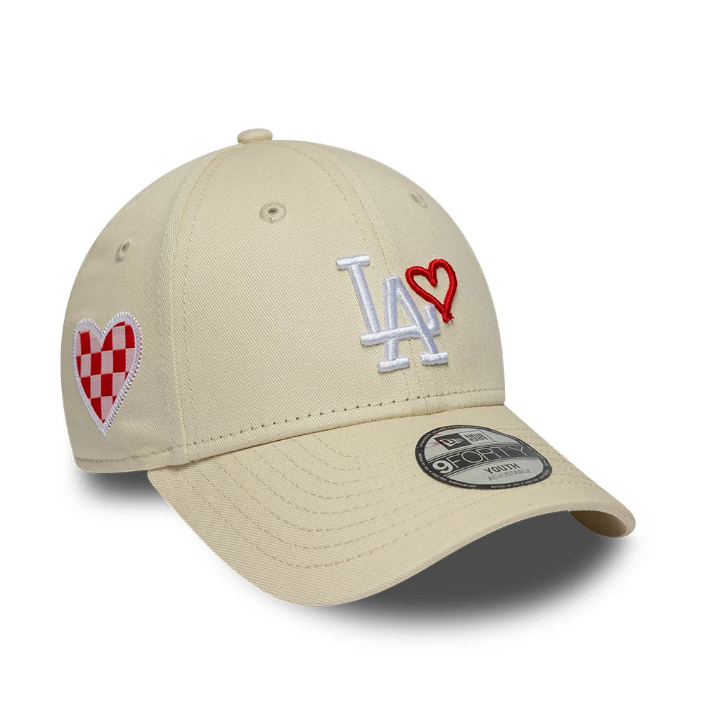 LA Dodgers Youth MLB Heart Icon Light Beige New Era 9FORTY Adjustable Cap, three-quarter view showing a white LA logo with a red heart outline on the front panel, a checkered red heart on the right side.